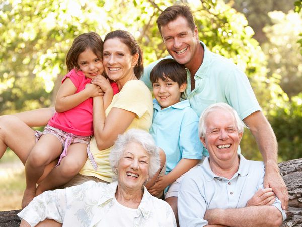 Eine glückliche Familie, drei Generationen: Enkel, Eltern, Großeltern - im Hintergrund Natur